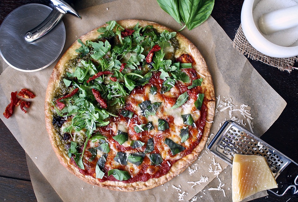 Frisch gebackene Pizza mit Basilikum auf einem Holztisch
